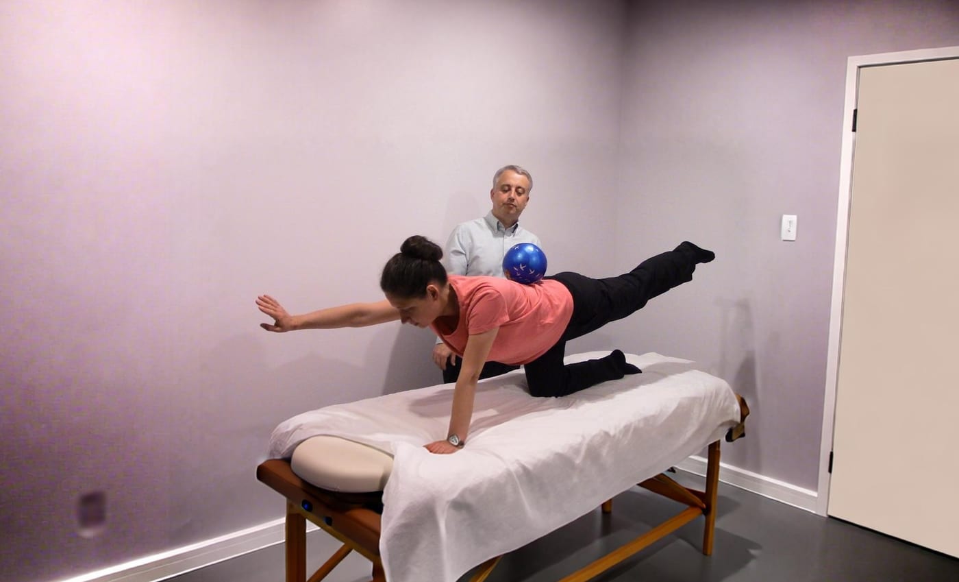 Vitaliy Korovyanskiy supervising a stability-ball balance exercise during an in-home injury-prevention session